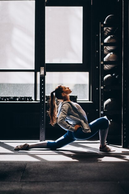 Портрет привлекательной молодой женщины делают упражнения йоги или пилатес