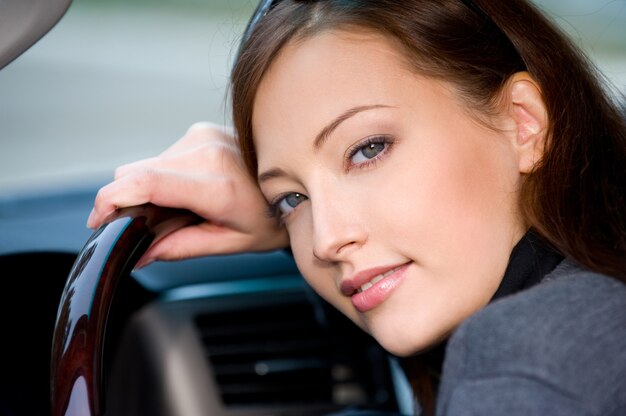 Portrait of attractive young woman in the new car  - outdoors