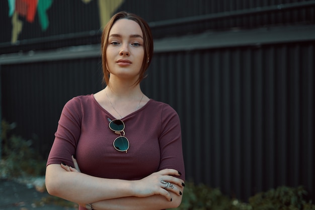 Portrait of attractive young woman posing against dark wall