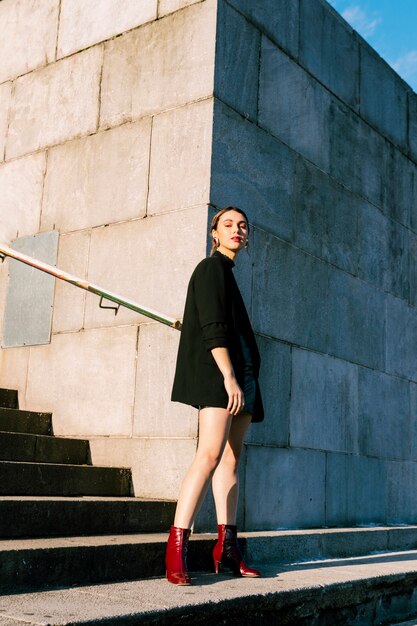 Portrait of an attractive young woman standing in front of wall