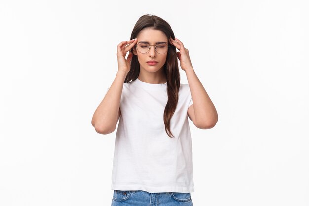 portrait of attractive young woman trying get ready, massaging temples with closed eyes as