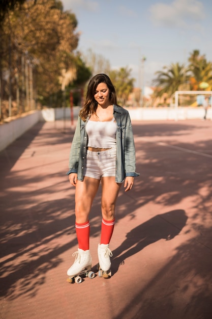 Foto gratuita ritratto di una giovane donna attraente con roller skate