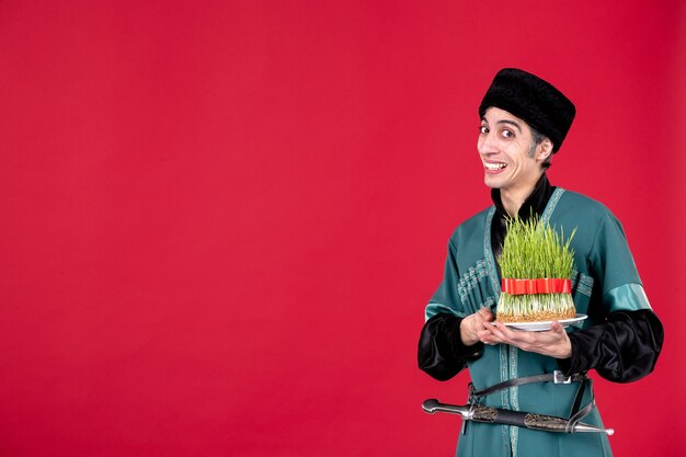 Portrait of azeri man in traditional costume giving semeni on red dancer ethnic holiday novruz spring