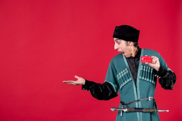 Portrait of azeri man in traditional costume holding credit card on red money ethnic novruz