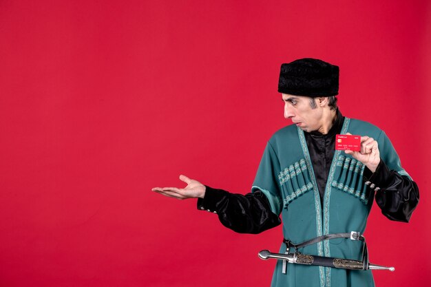 Portrait of azeri man in traditional costume holding credit card on red spring money ethnic novruz photo