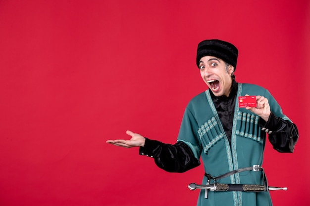 Free photo portrait of azeri man in traditional costume holding credit card on red spring money novruz