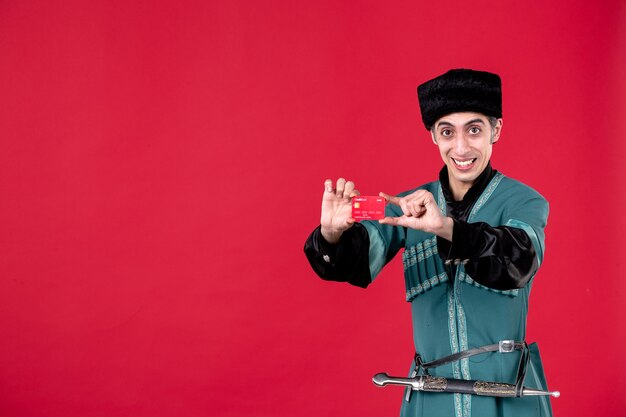 Portrait of azeri man in traditional costume holding credit card studio shot red ethnic novruz spring money color