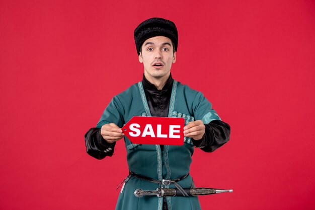 Portrait of azeri man in traditional costume holding sale nameplate red