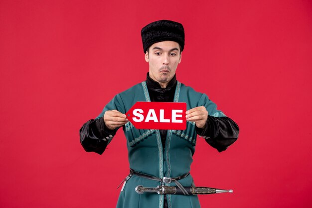 Portrait of azeri man in traditional costume holding sale nameplate red