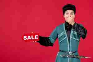 Free photo portrait of azeri man in traditional costume holding sale nameplate redshopping spring novruz dancers