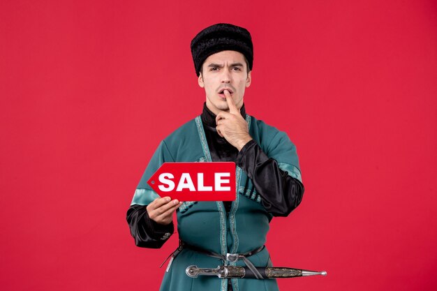 Portrait of azeri man in traditional costume holding sale nameplate