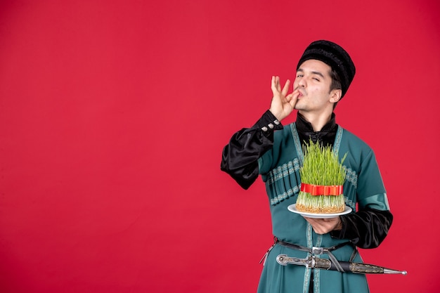 Portrait of azeri man in traditional costume holding semeni studio shot red concept performer spring