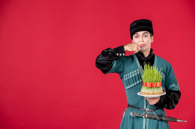 Portrait of azeri man in traditional costume holding semeni studio shot on red novruz concept dancer spring
