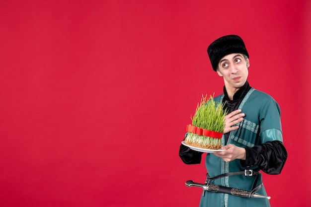 Portrait of azeri man in traditional costume with semeni on red ethnic spring dancers holiday novruz