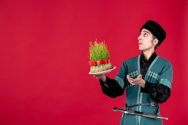 Portrait of azeri man in traditional costume with semeni on red holiday ethnic spring dancer