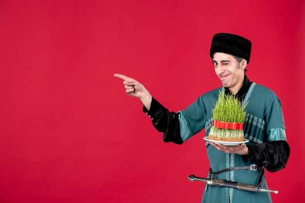 Portrait of azeri man in traditional costume with semeni on red novruz dancer holiday spring