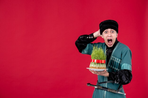 Portrait of azeri man in traditional costume with semeni on red novruz ethnic spring holiday