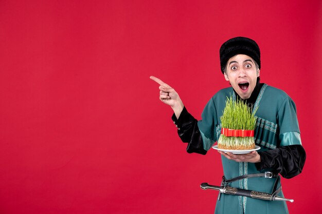 Portrait of azeri man in traditional costume with semeni on red novruz holiday spring dancer