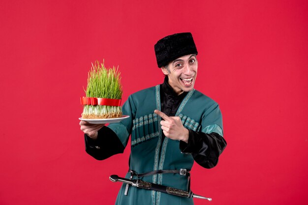 Portrait of azeri man in traditional costume with semeni on red