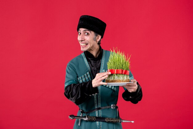 Portrait of azeri man in traditional costume with semeni on red