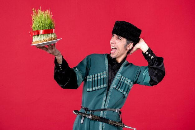 Portrait of azeri man in traditional costume with semeni on red