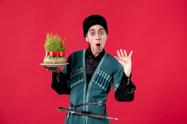 Portrait of azeri man in traditional costume with semeni on red