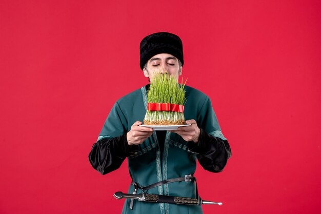 Portrait of azeri man in traditional costume with semeni on red