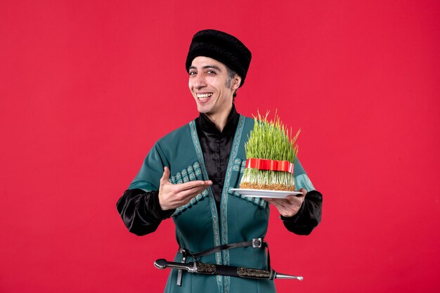 Portrait of azeri man in traditional costume with semeni on red