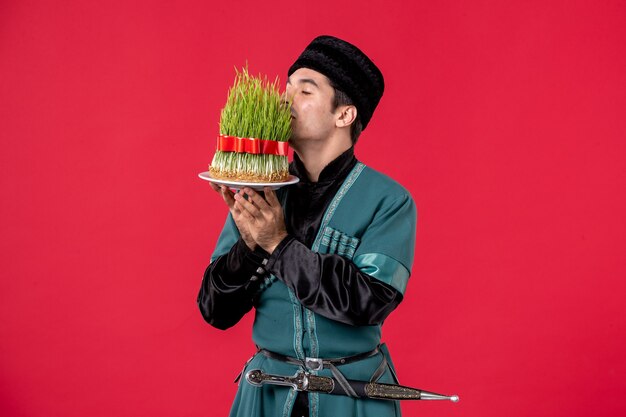 Portrait of azeri man in traditional costume with semeni on red