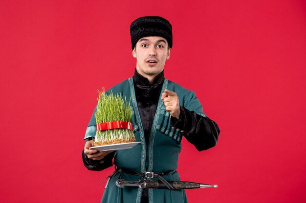 Portrait of azeri man in traditional costume with semeni on red