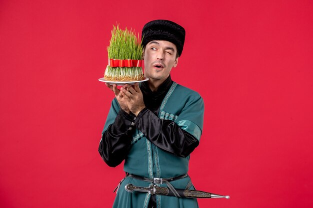 Portrait of azeri man in traditional costume with semeni on red