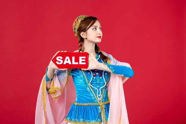 赤の販売ネームプレートを保持している伝統的なドレスのアゼルバイジャン語の女性の肖像画