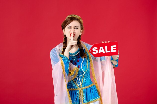 赤の販売ネームプレートを保持している伝統的なドレスのアゼルバイジャン語の女性の肖像画