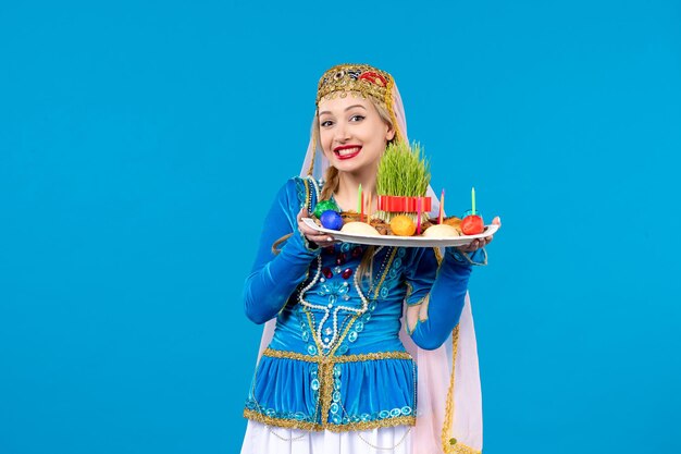 novruzxoncaスタジオで伝統的なドレスを着たアゼルバイジャンの女性の肖像画は青い背景の概念の民族ダンサーを撮影しました