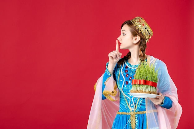 Free photo portrait of azeri woman in traditional dress with semeni on red