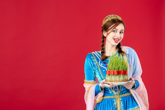 Portrait of azeri woman in traditional dress with semeni on red