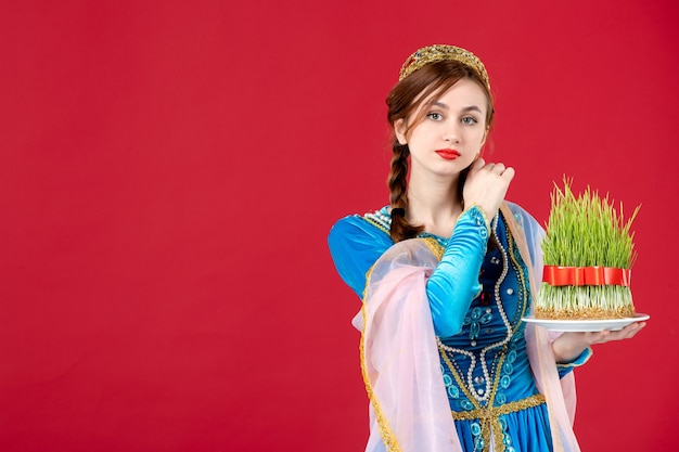 Free photo portrait of azeri woman in traditional dress with semeni on red