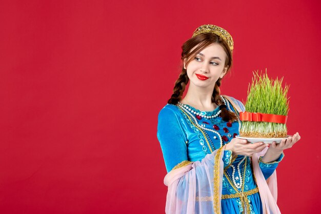 Portrait of azeri woman in traditional dress with semeni on red