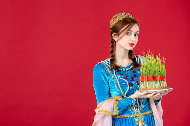 Portrait of azeri woman in traditional dress with semeni on red