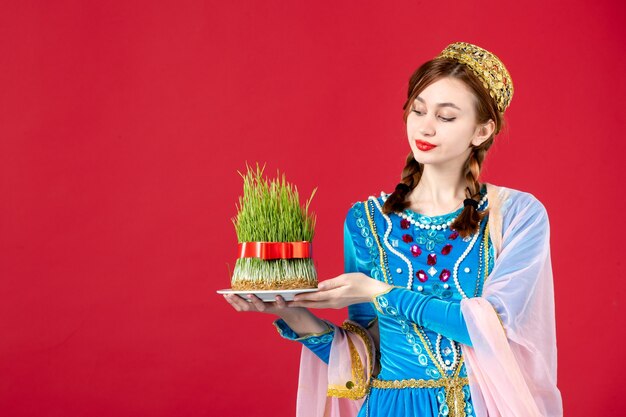 Free photo portrait of azeri woman in traditional dress with semeni on red