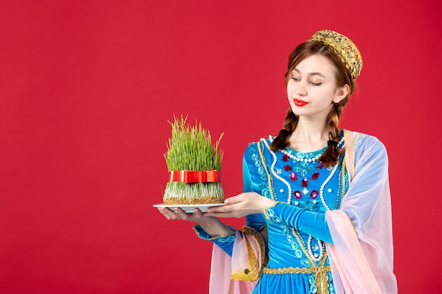 Portrait of azeri woman in traditional dress with semeni on red