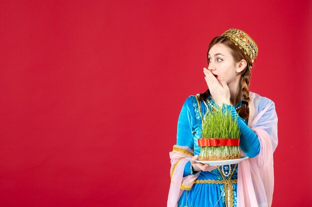 Free photo portrait of azeri woman in traditional dress with semeni on red