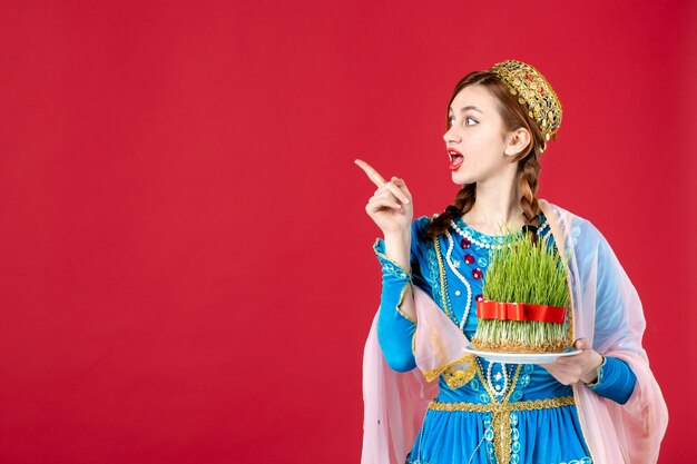 Portrait of azeri woman in traditional dress with semeni on red