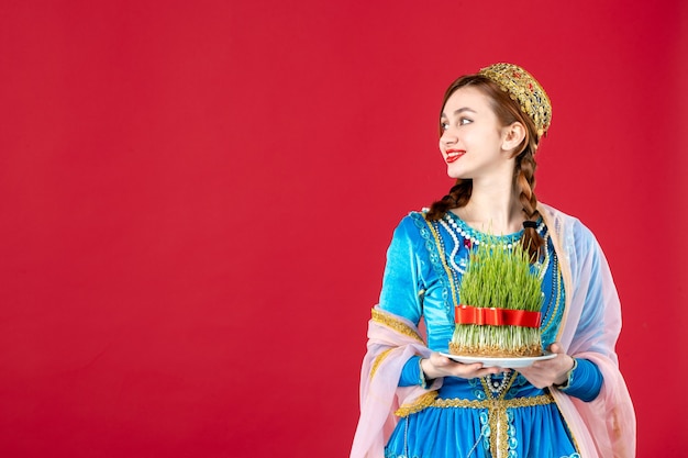 Free photo portrait of azeri woman in traditional dress with semeni on red