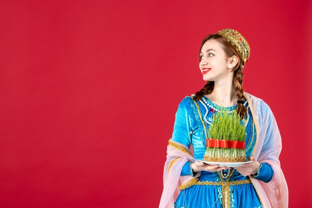 Portrait of azeri woman in traditional dress with semeni on red