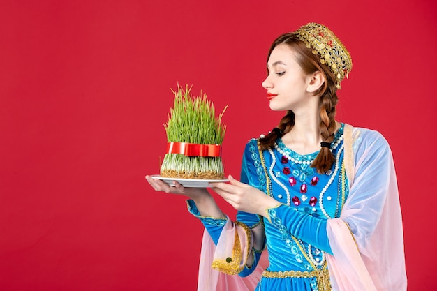 Free photo portrait of azeri woman in traditional dress with semeni on red