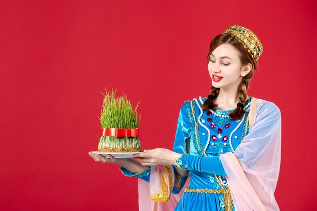 Portrait of azeri woman in traditional dress with semeni on red