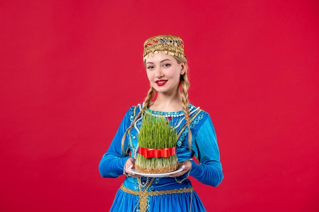 Foto gratuita ritratto di donna azera in abito tradizionale con semeni studio girato sfondo rosso concetto ballerino primavera