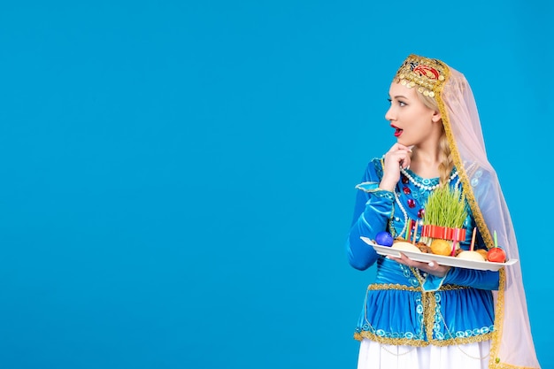 Portrait of azeri woman in traditional dress with xonca studio shot blue background concept dancer novruz spring