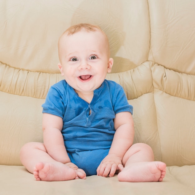 Portrait of baby boy sitting on sofa